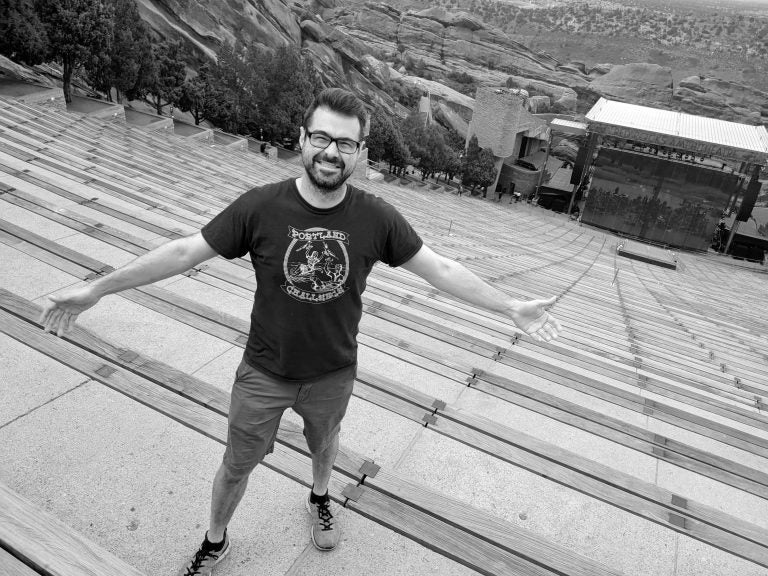 Black and white photograph of Will standing on the steps of a venue