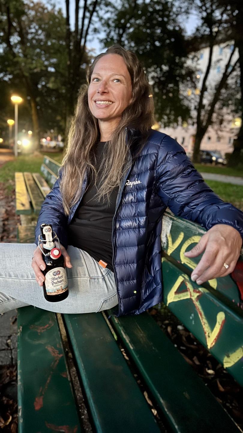 Photograph of Jennifer sitting on a park bench smiling