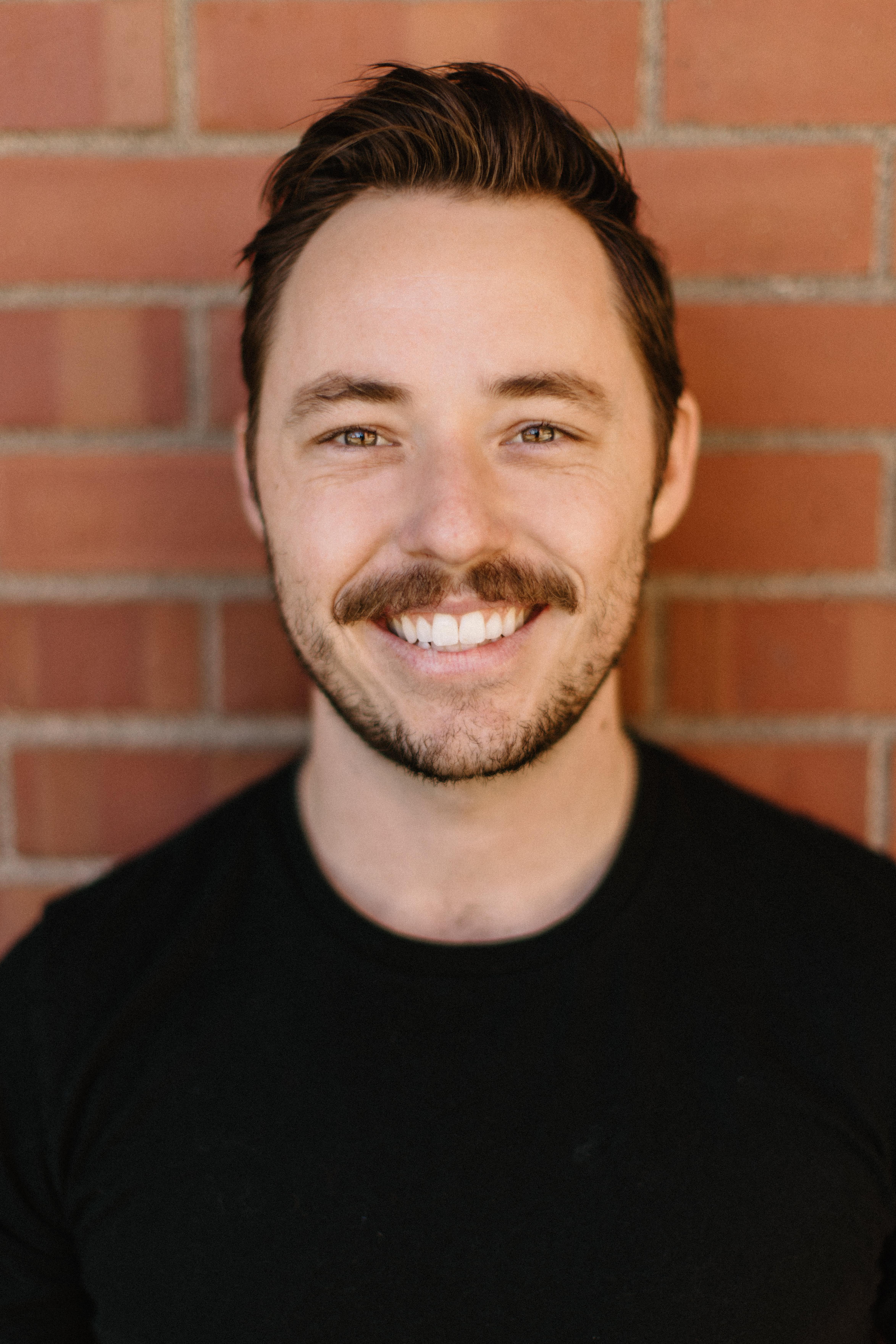 Headshot of Alex smiling.