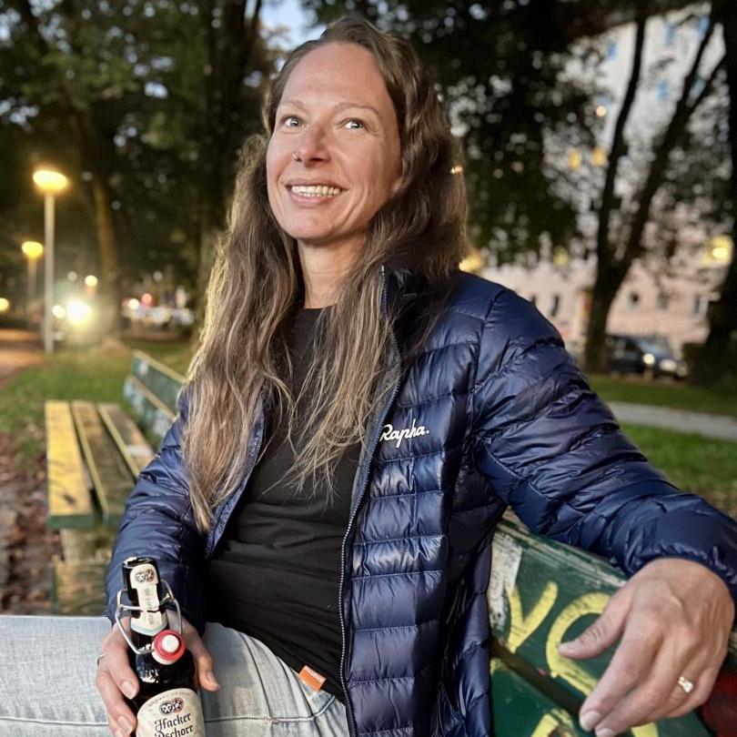 Photograph of Jennifer sitting on a park bench smiling